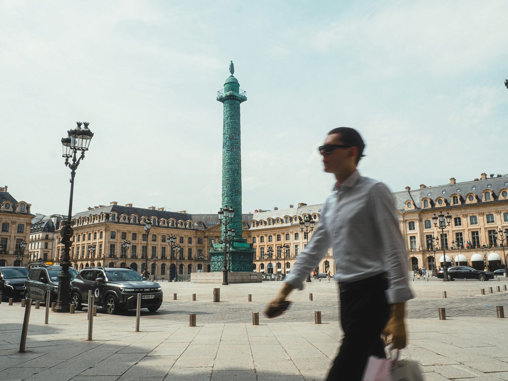 Man walks past vendome column in paris.